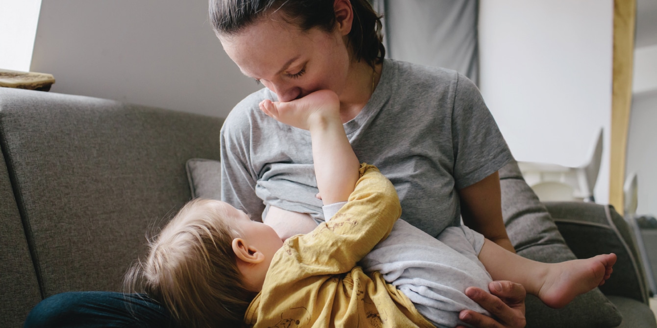 mom breastfeeding baby in the evening at home and trying to reach her extended breastfeeding goals