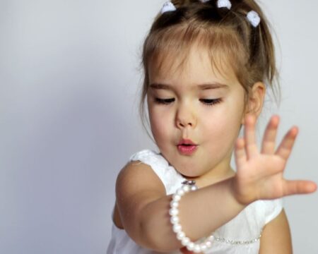 little girl looking at her bracelet birthstones by month meanings Motherly