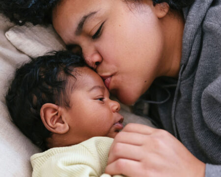 mom giving her newborn baby a kiss