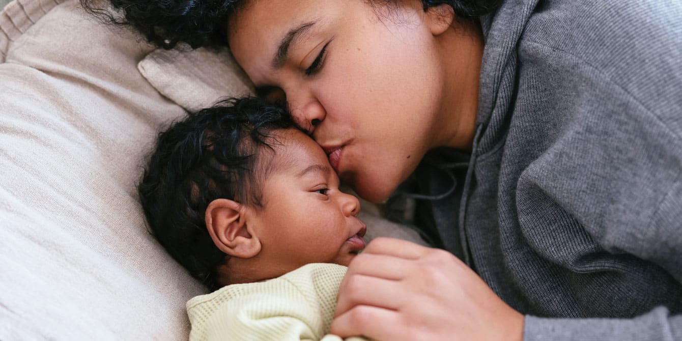 mom giving her newborn baby a kiss- nicu baby experience