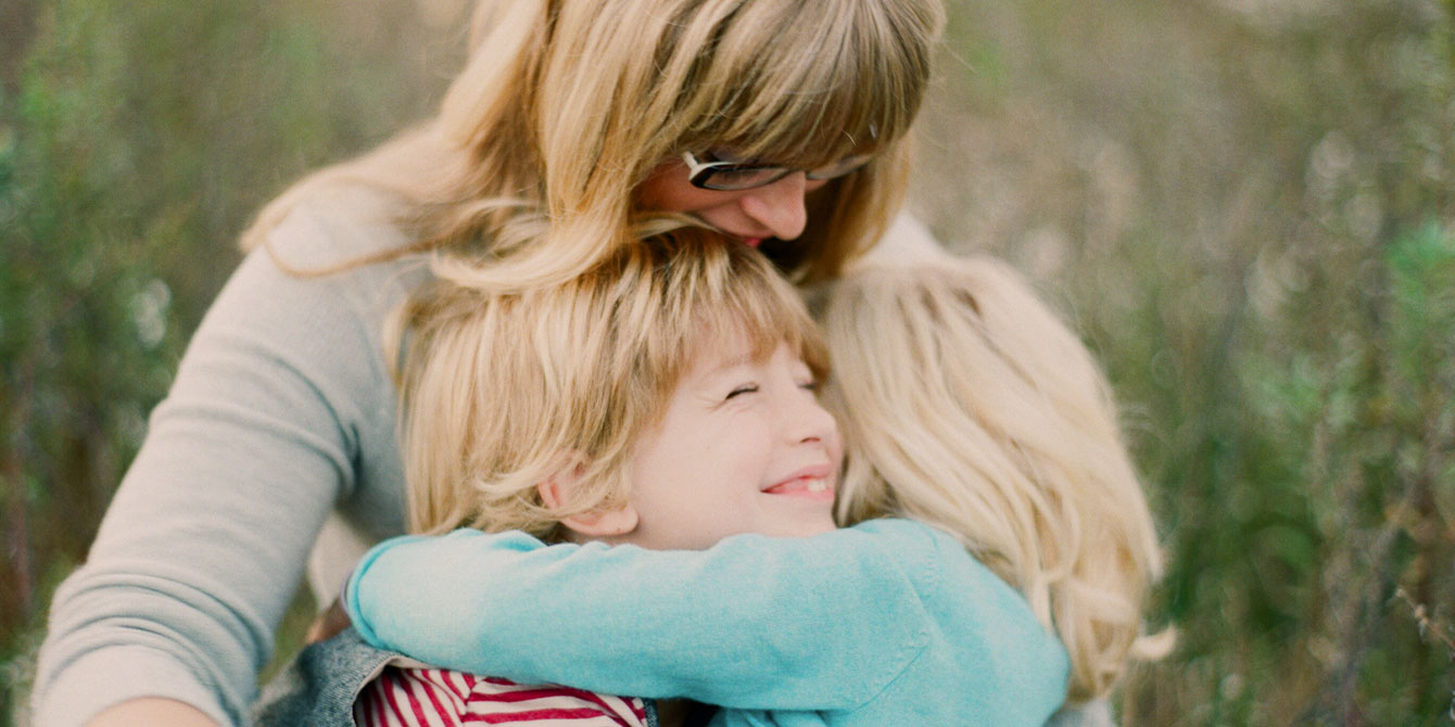 Mom and two kids hugging