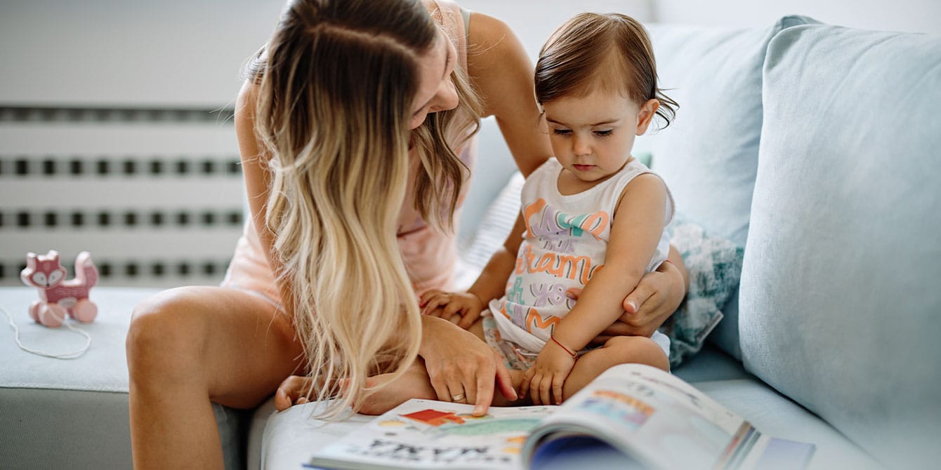 mom reading a book to her firstborn child