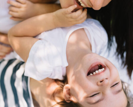 mom tickling her son outdoors