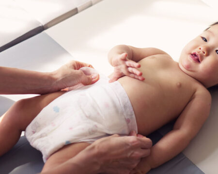 parent changing babys diaper Motherly