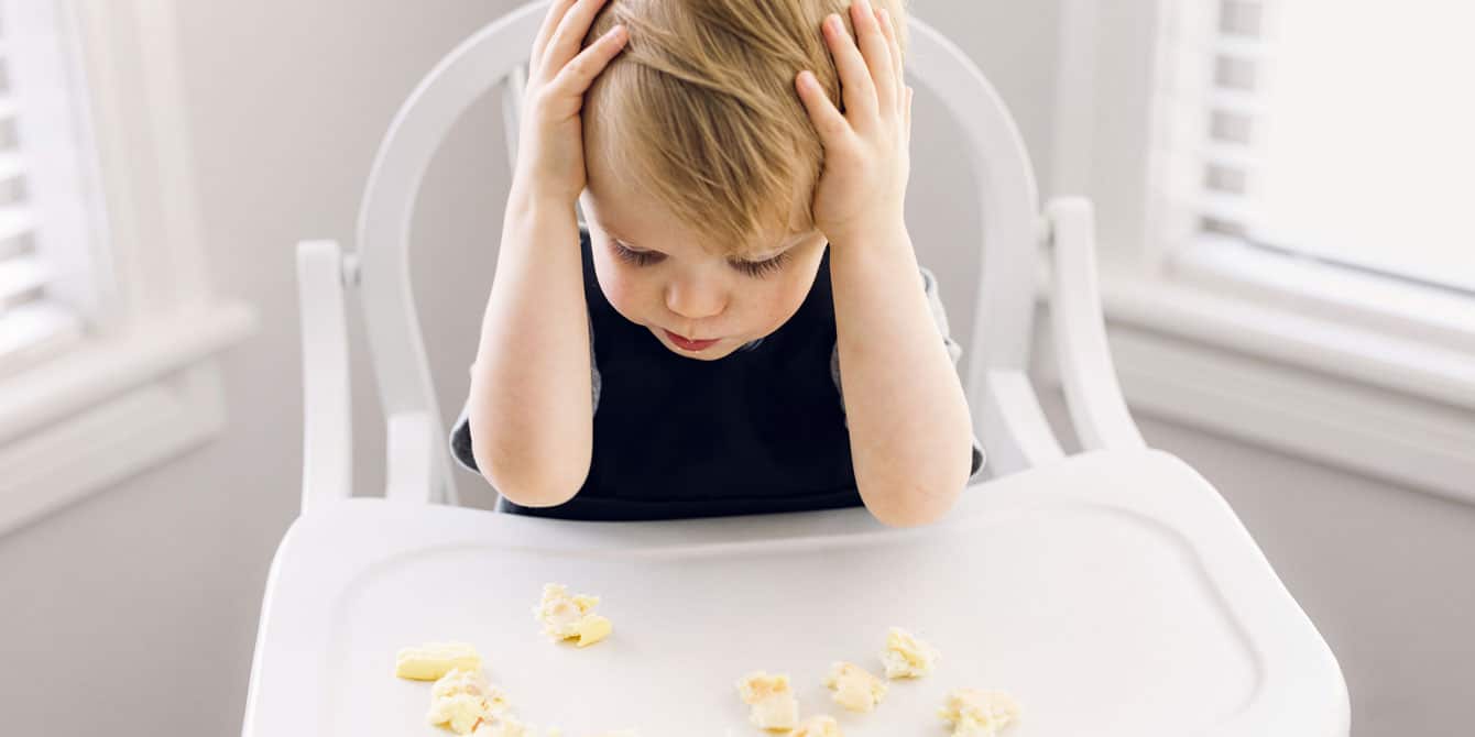 child on toddler food strike sitting in high chair