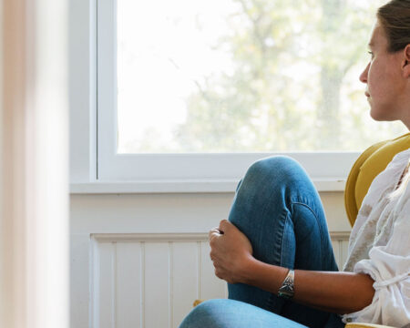 woman sitting by herself looking out the window Motherly