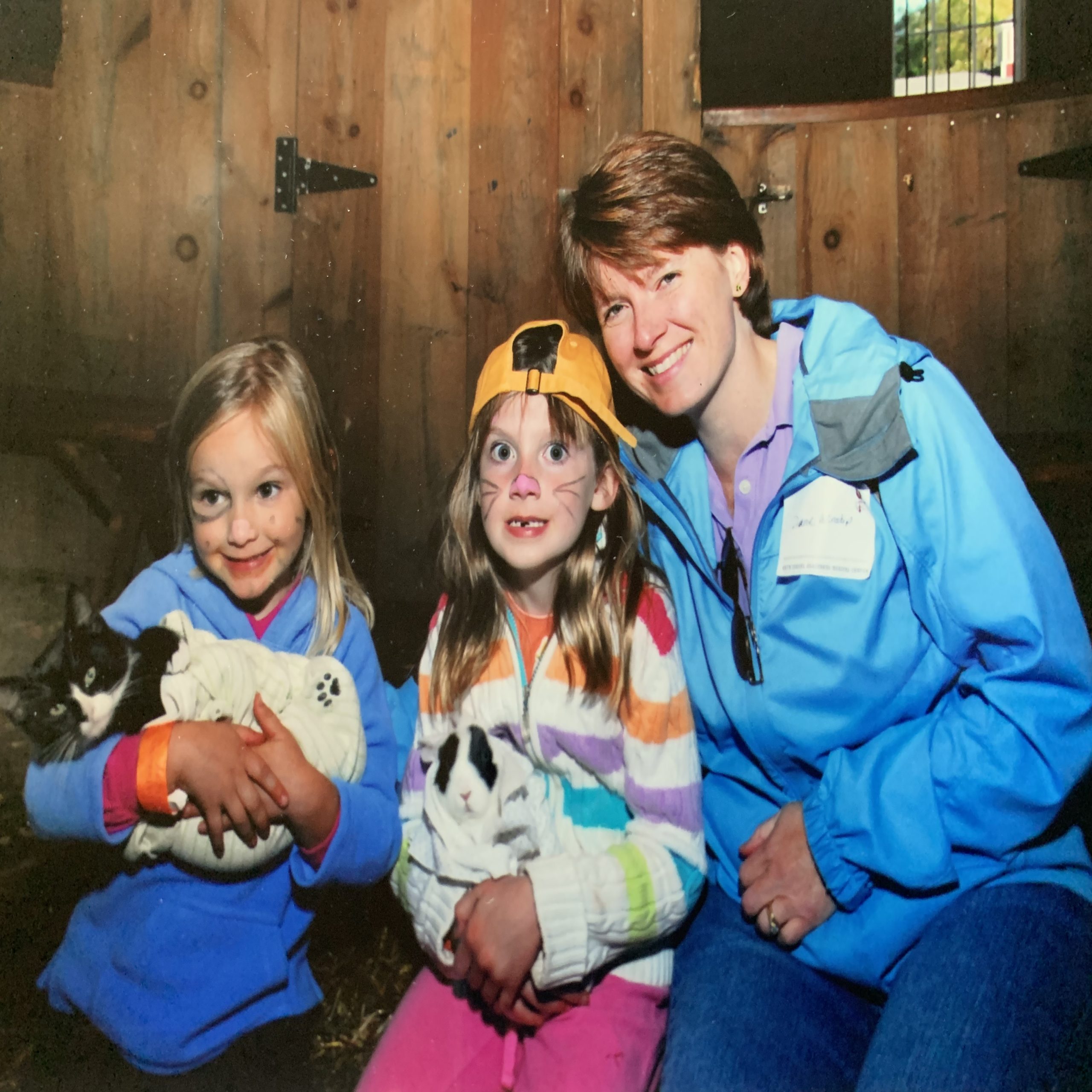 little girls holding animals with mom
