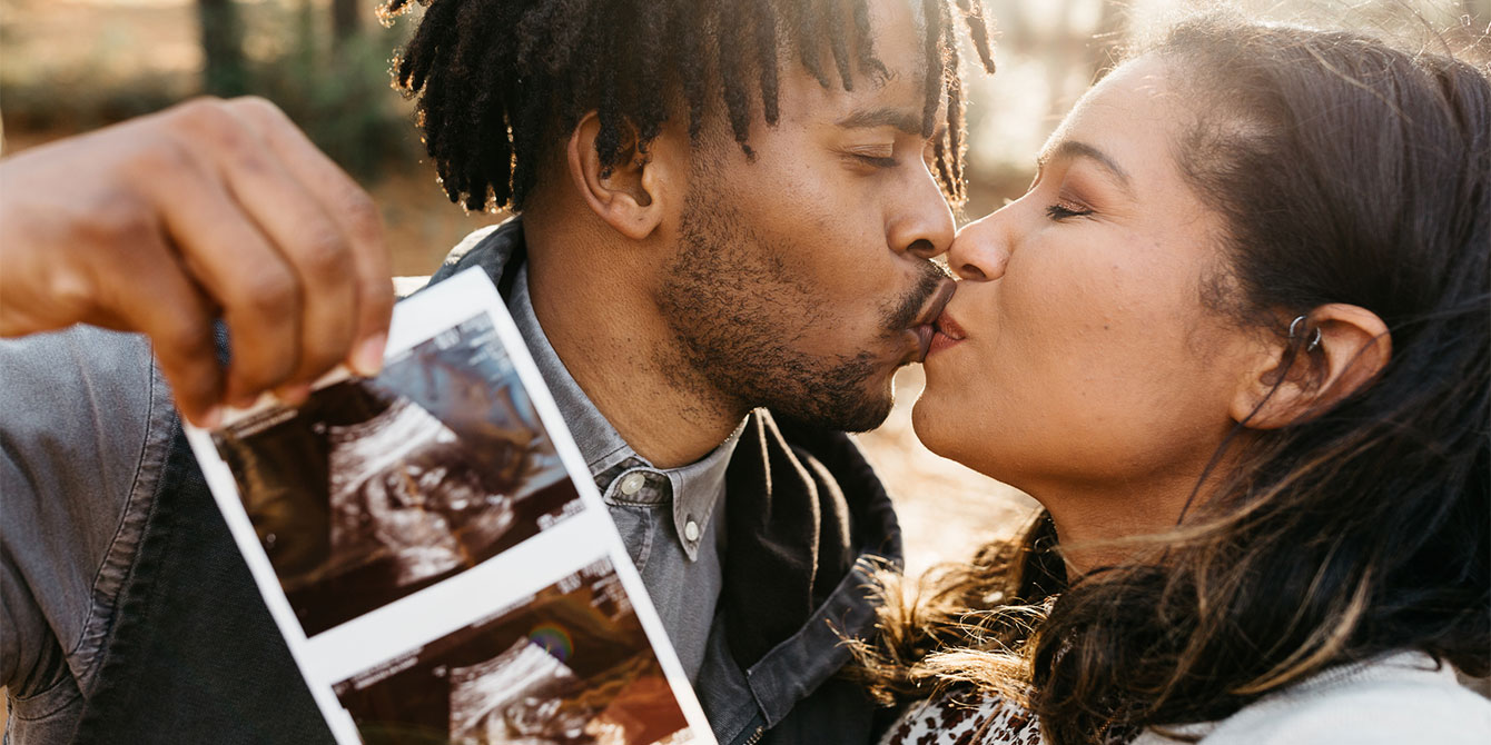 couple kissing while holding an ultrasound - best men's fertility supplements