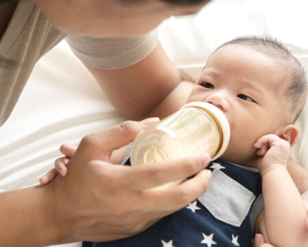 formula feeding mom feeding her newborn baby a bottle