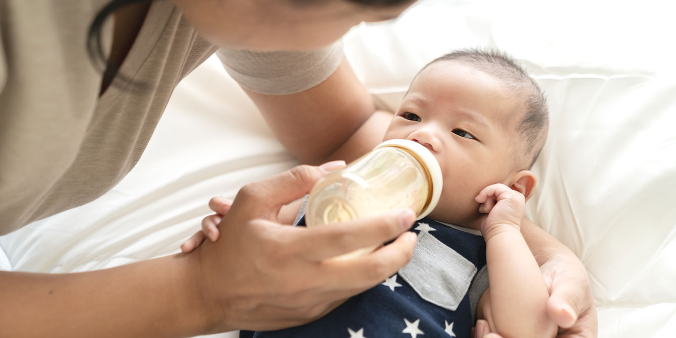 formula feeding mom feeding her newborn baby a bottle