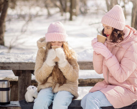 mom and daughter drinking hot cocoa outside