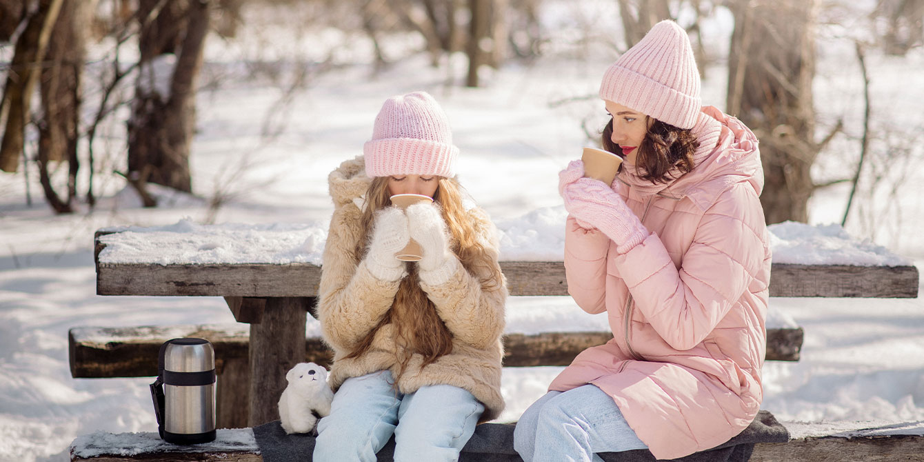 mom and daughter drinking hot cocoa outside celebrating nontraditional holidays