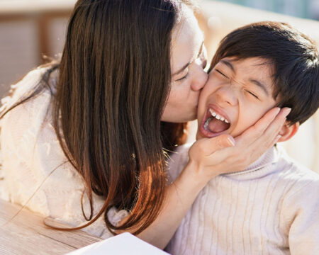mom kissing her son on the cheek