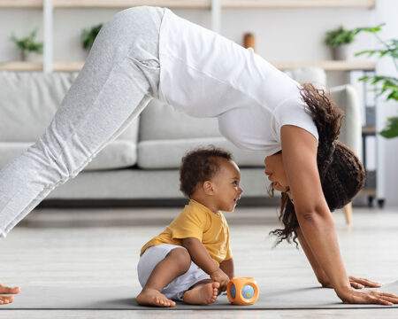 mom finding time to exercise practicing yoga with her baby son