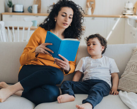 mom reading a book to her boy toddler teaching diversity and inclusion to kids Motherly