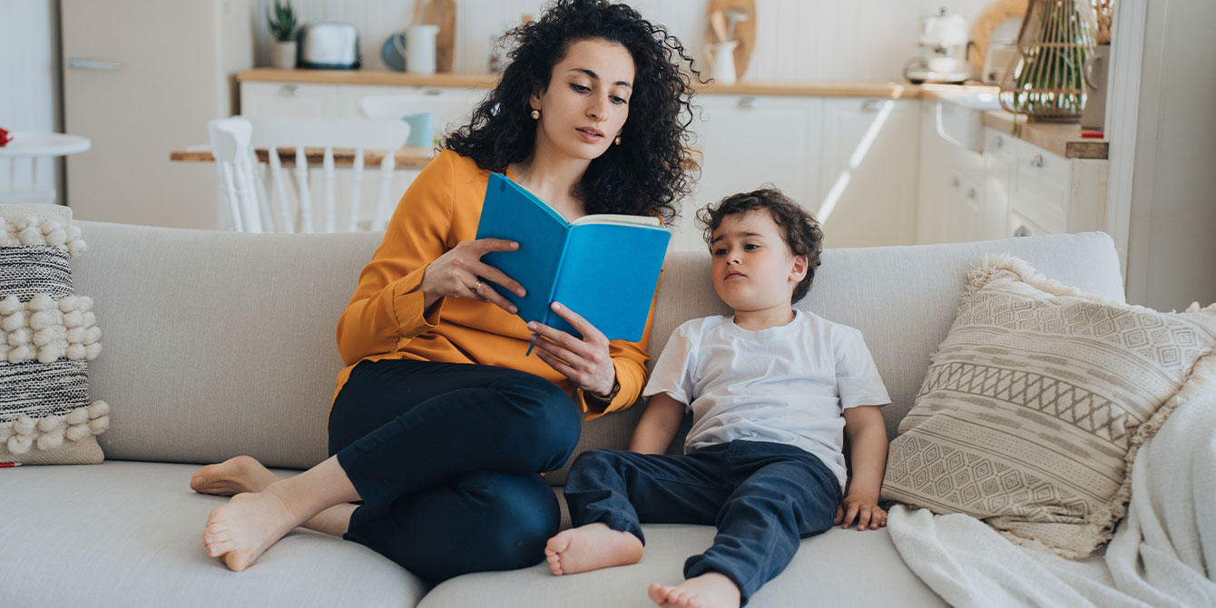 mom reading a book to her son -teaching diversity and inclusion to kids