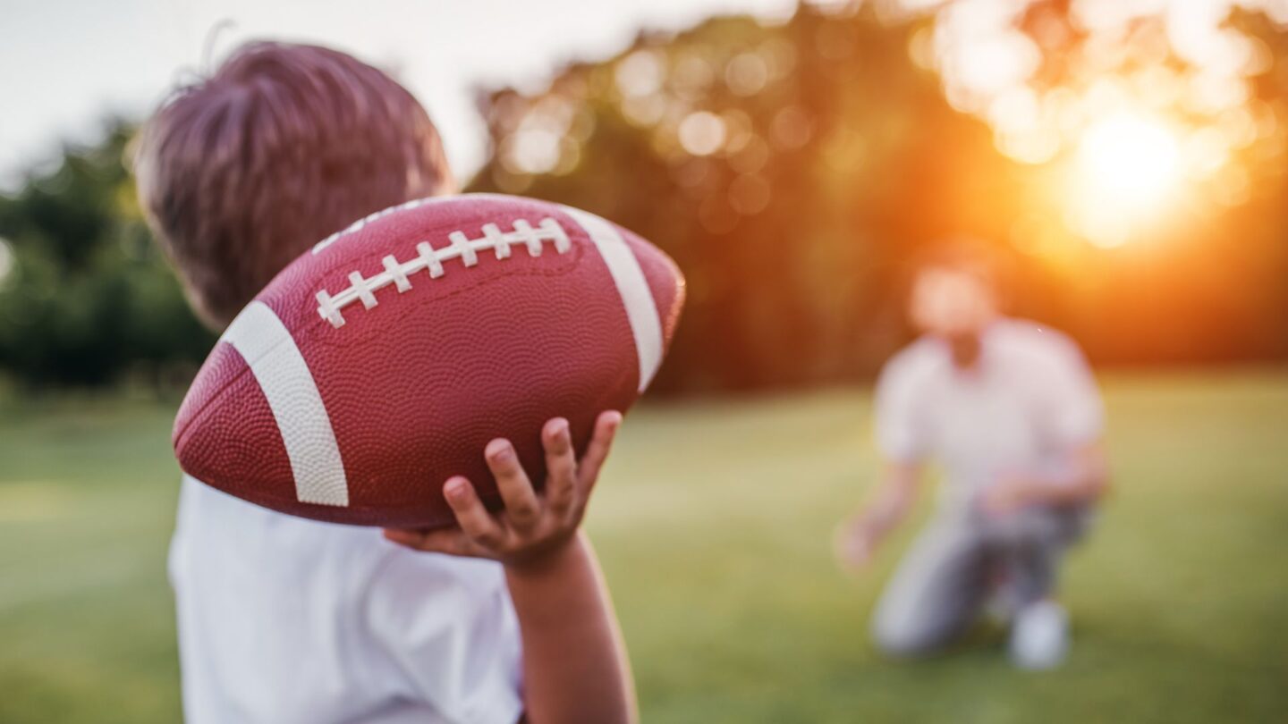 should i let my kid play football child throwing football