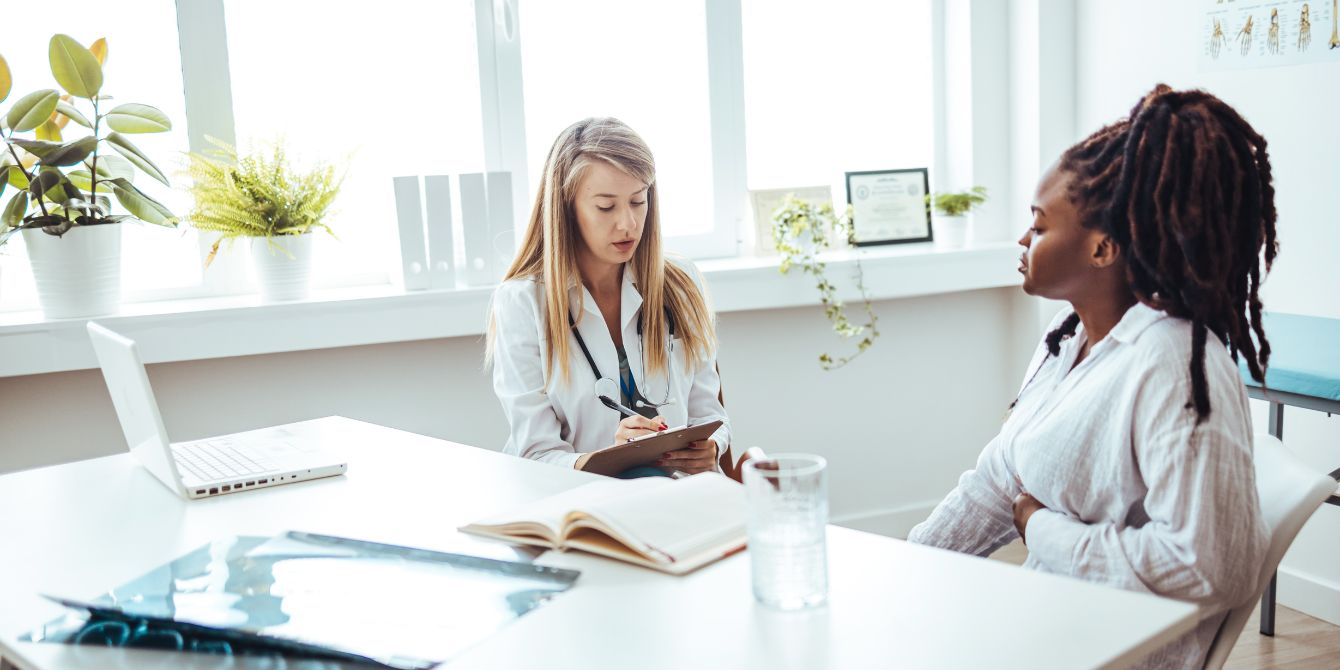 woman meeting with doctor in office - medical gaslighting is common in women's health