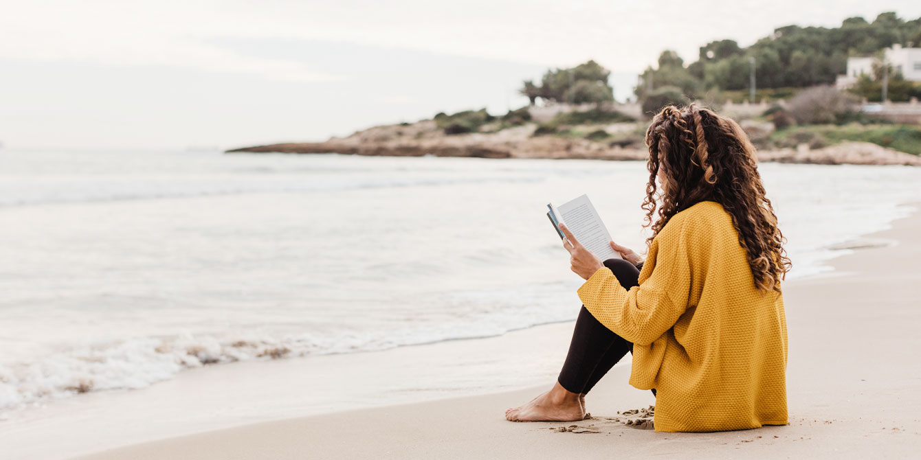 woman reading on the beach by herself - miscarriage quotes