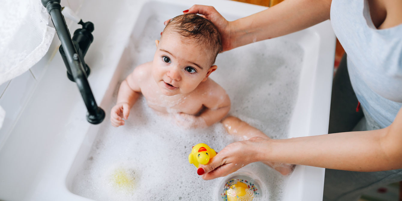 baby taking a bubble bath - bath safety tips