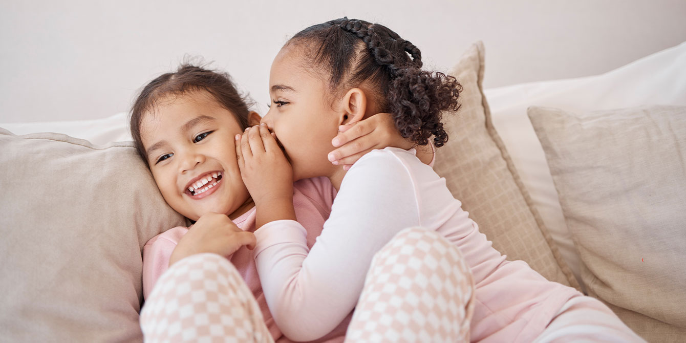 best friends whispering and laughing-no sleepover rule