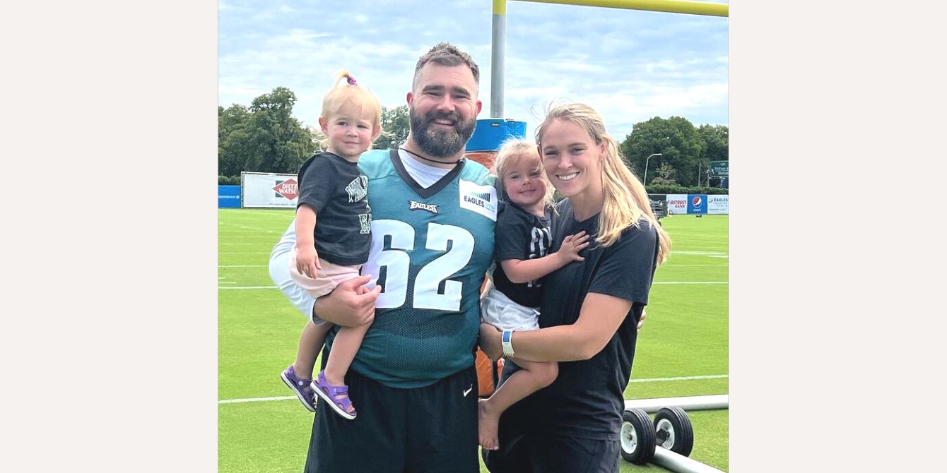 Jason Kelce and his family posing for a photo on the football field