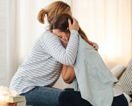 mom hugging teen daughter cdc report teen girls in crisis Motherly