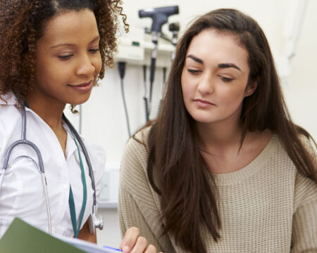 nurse showing patient test results Motherly