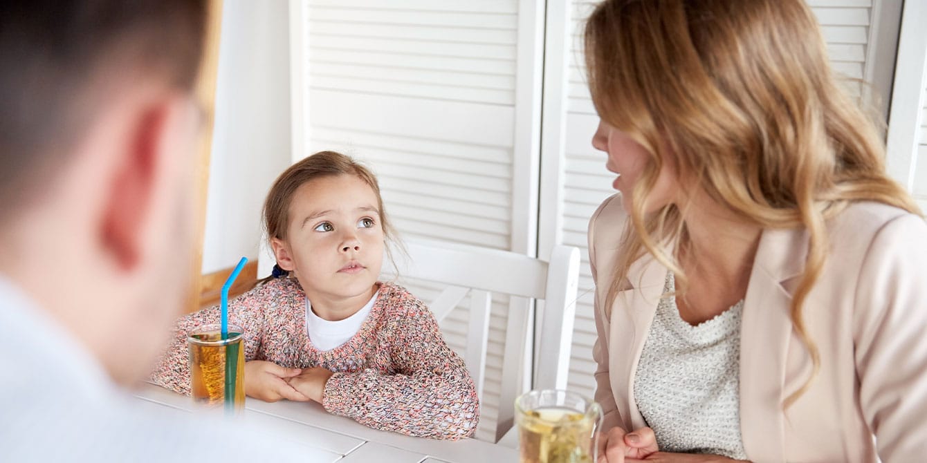 parents talking with child at dining table about how to reduce gun violence