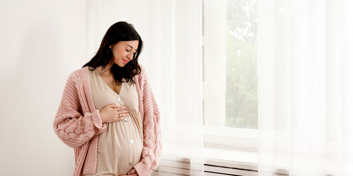 first time mom smiling at pregnant belly