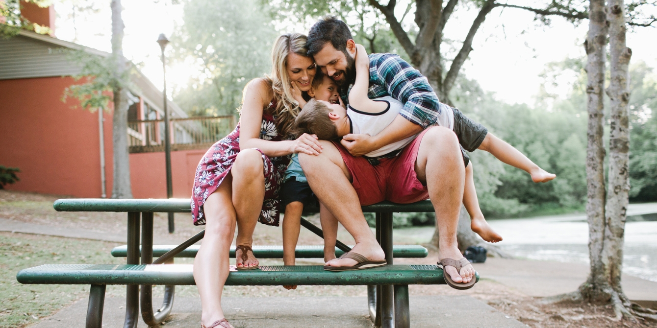 mom dad and two boys sitting on a park table - spring break activities