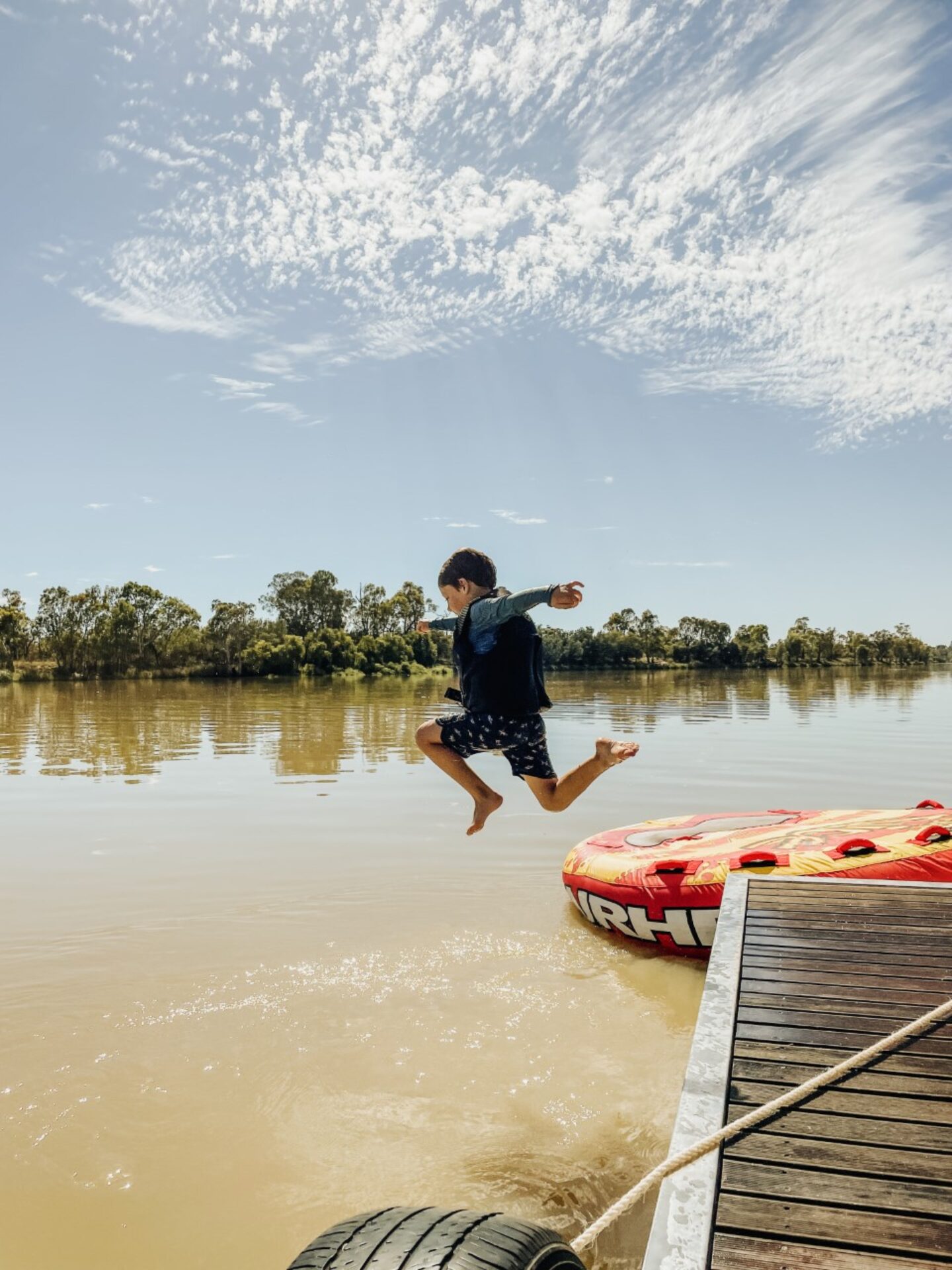 boy jumping into water