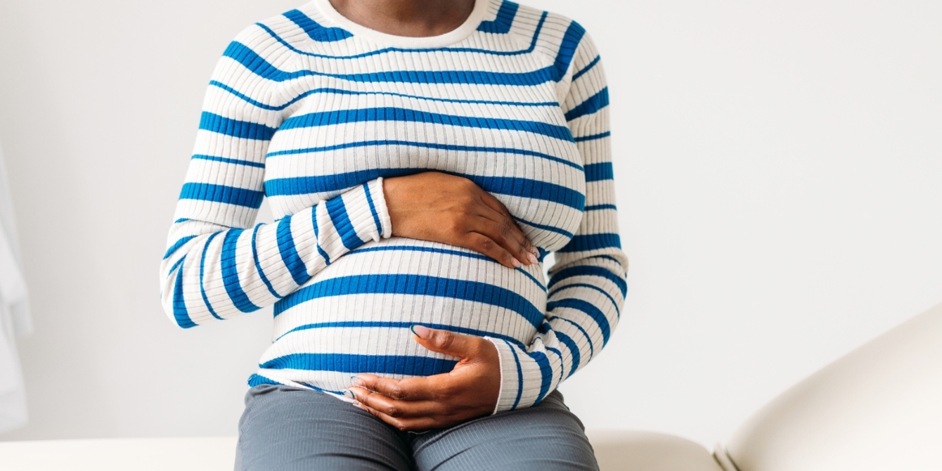 woman holds pregnant belly - cdc maternal mortality report