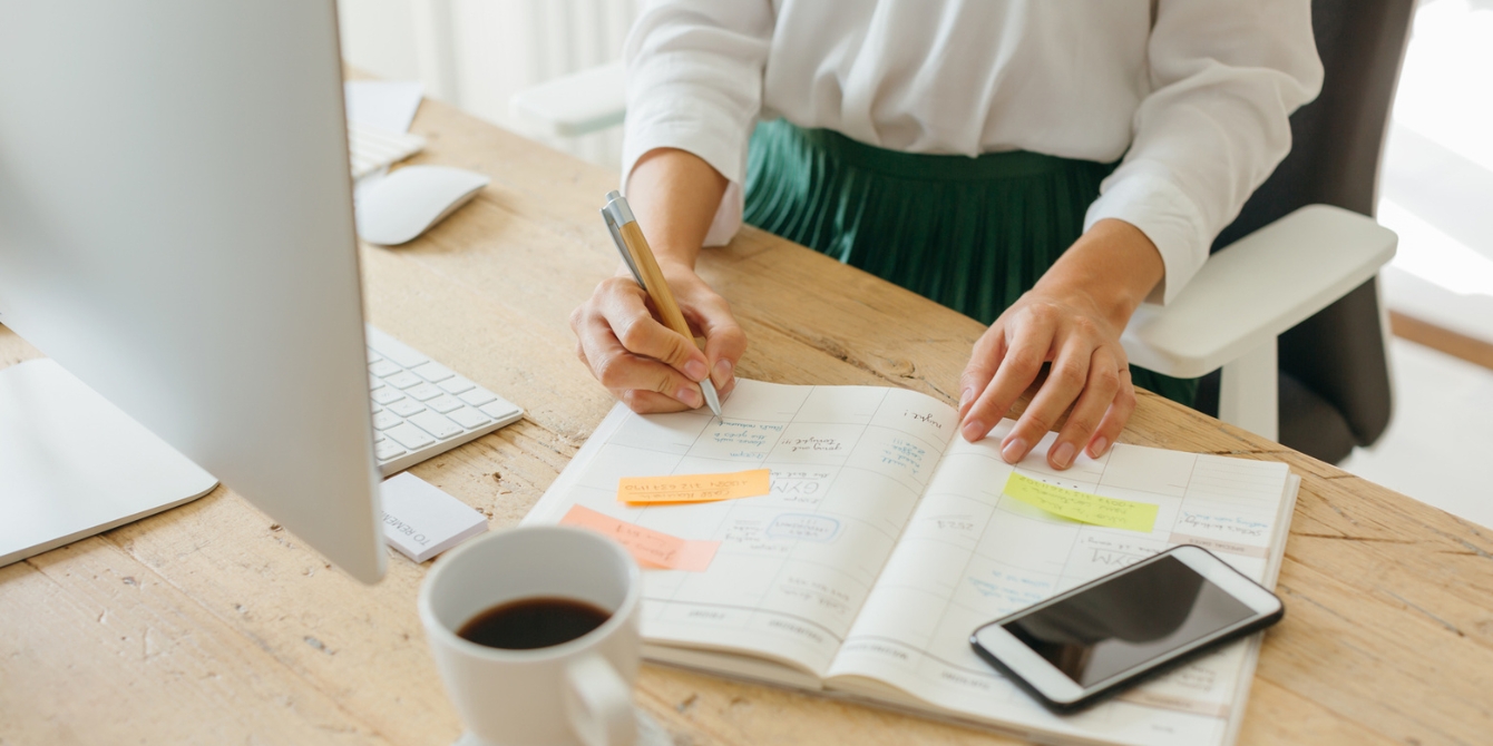 mom writing in her journal using productivity hacks to get things done