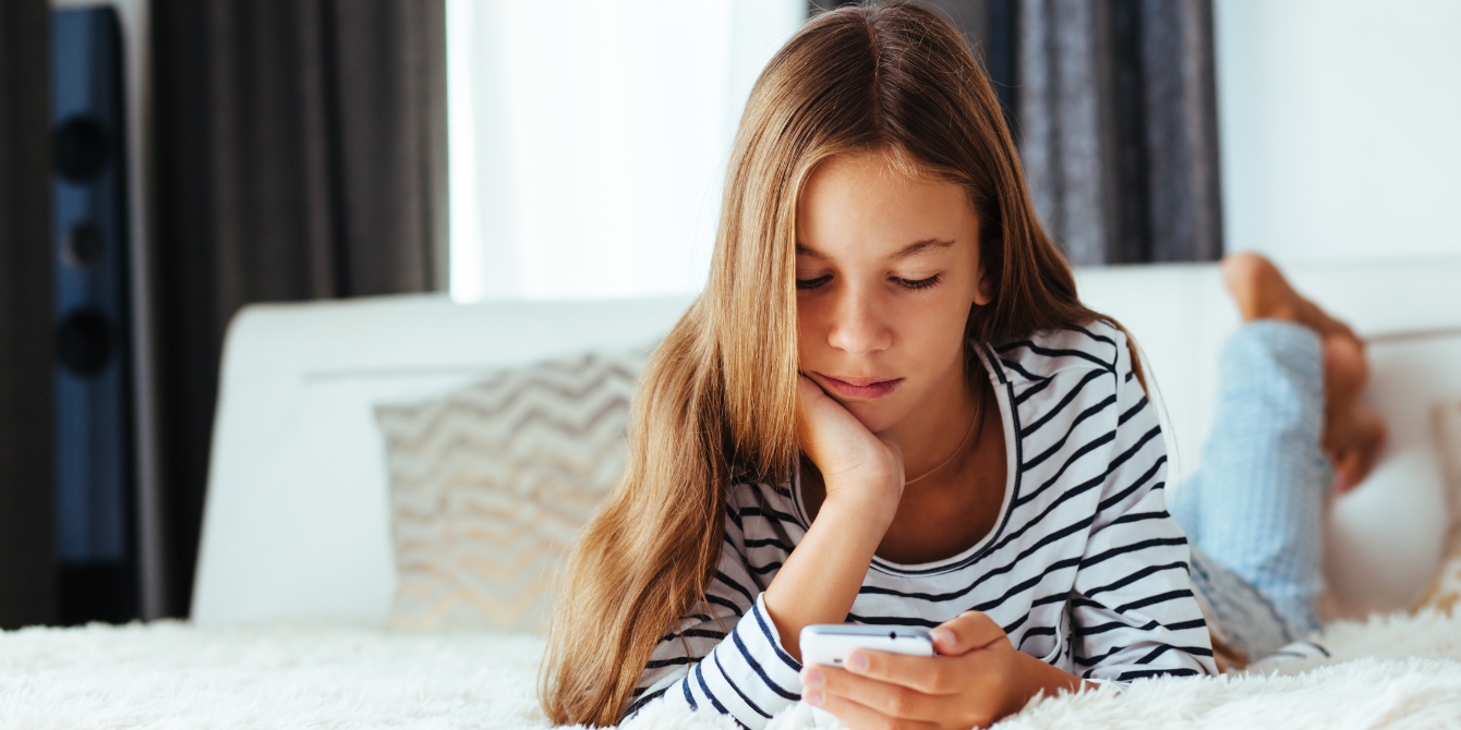 teen looking at smartphone - wait until 8th