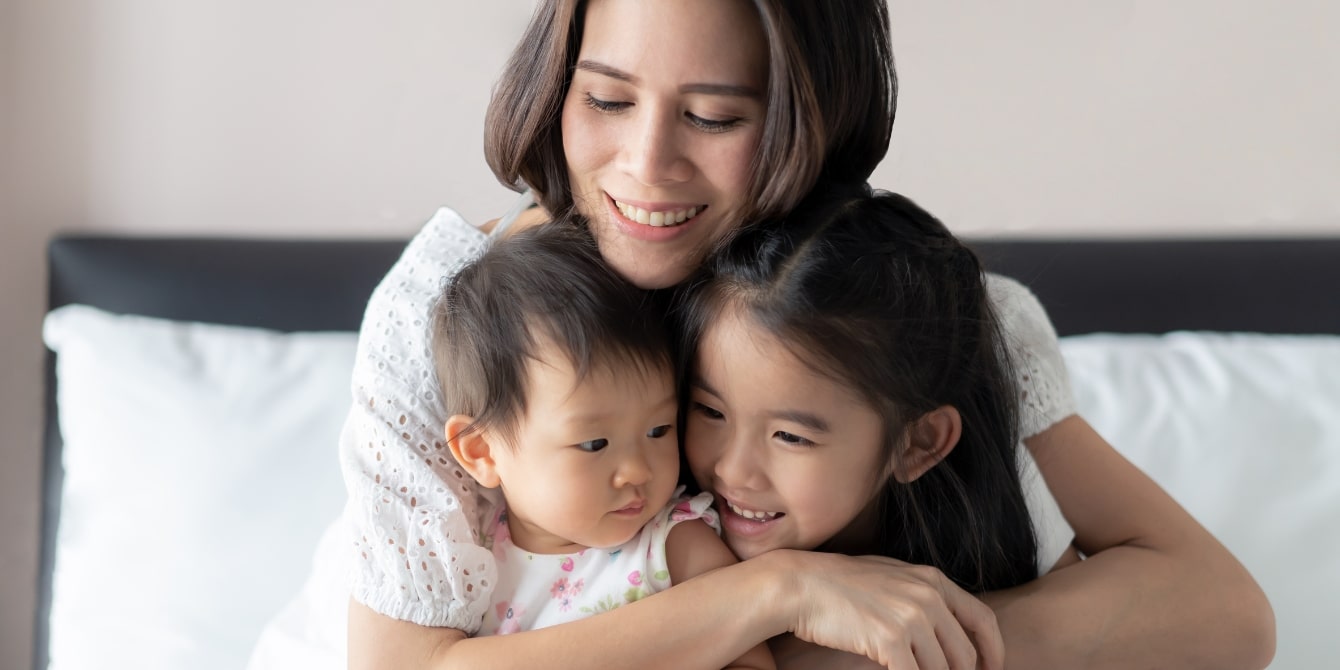 mom hugging her two kids - peaceful parenting helps parents and kids