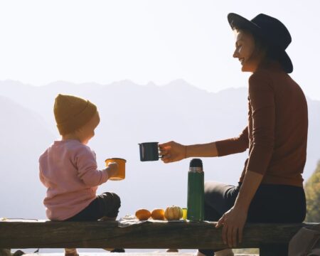 toddler and mom picnic holding mugs Motherly