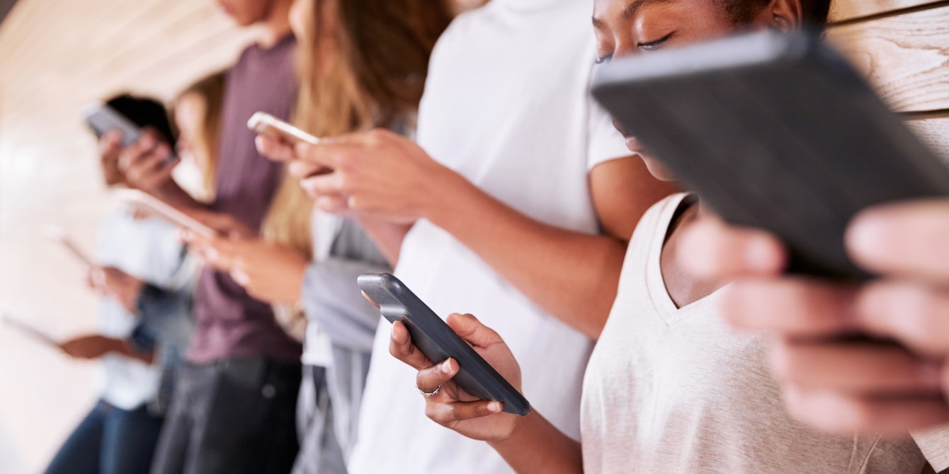 group of teens using smart phones - apa guidelines on social media