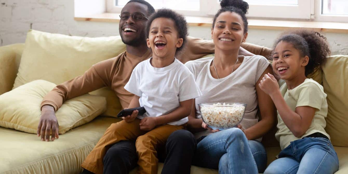 happy-laughing-family-on-couch-watching-movie