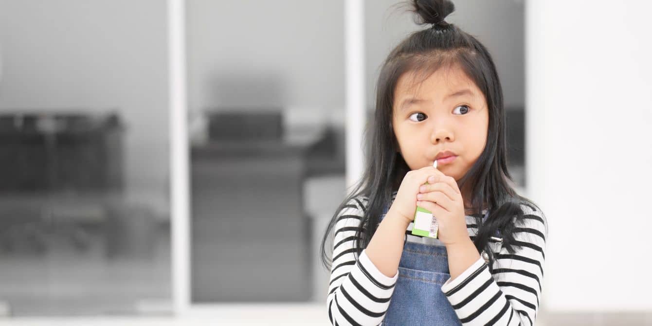 young girl drinking apple juice - arsenic in apple juice