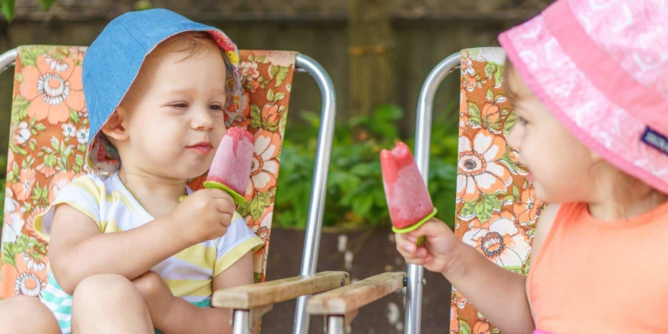 two kids in bucket hats eating popsicles- popsicle recipe