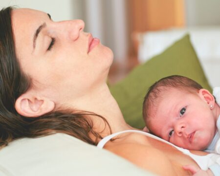 tired mom holding newborn baby Motherly