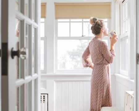 woman alone staring out house window Motherly