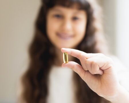 young teen girl holding vitamin Motherly