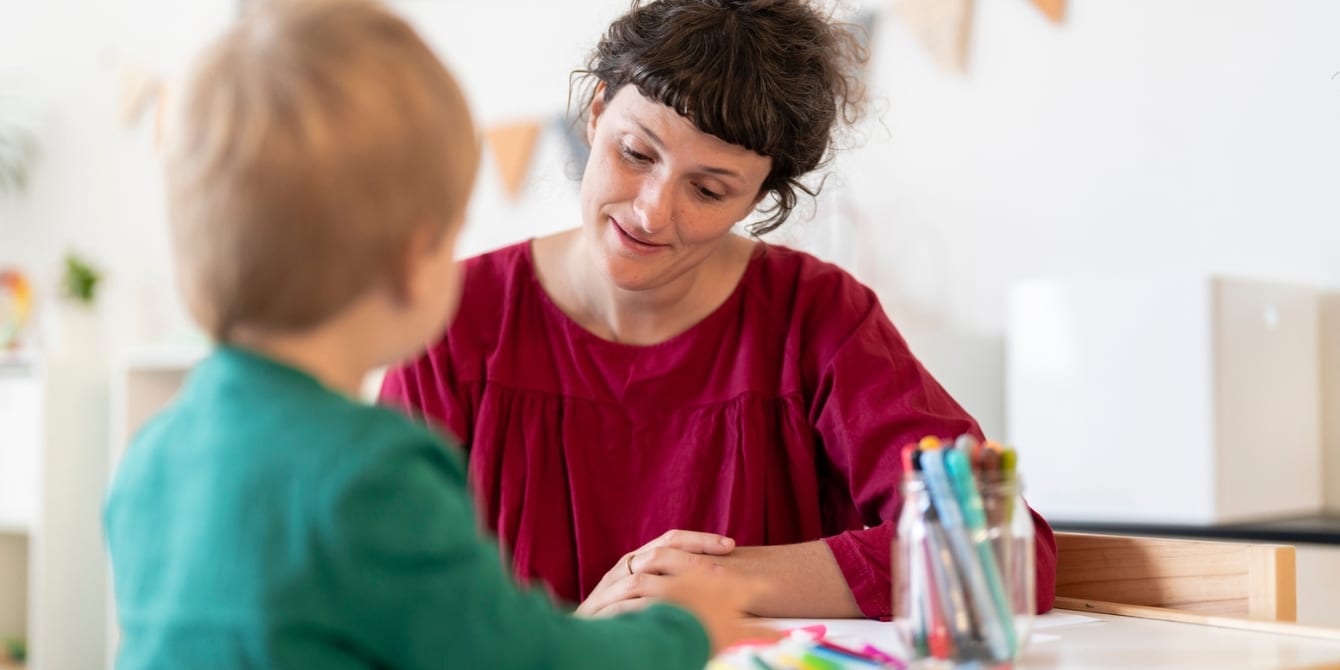 daycare worker coloring with young boy - childcare cliff
