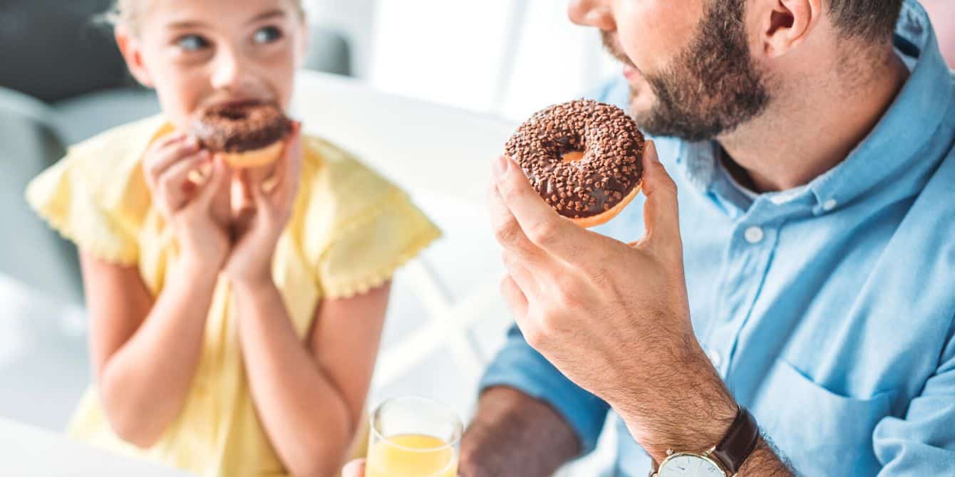 Girl eating donuts with her dad