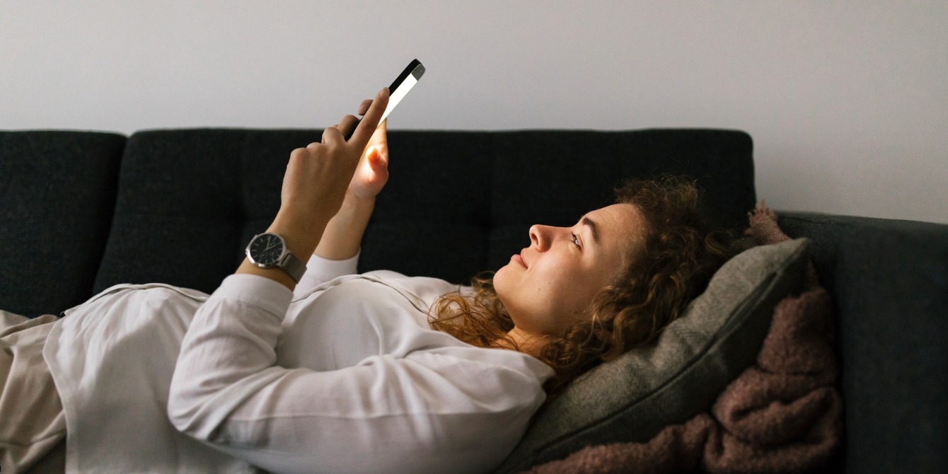 pregnant woman looking at phone - evening light exposure and gestational diabetes risk