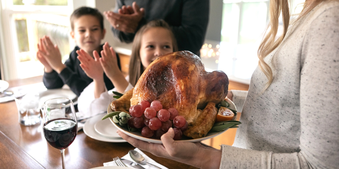https://www.mother.ly/wp-content/uploads/2023/10/woman-bringing-thanksgiving-turkey-in-to-her-family.jpeg