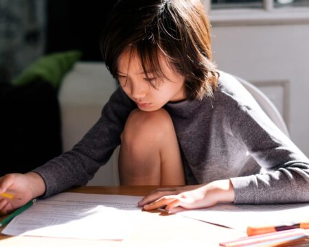 boy doing homework at kitchen table Motherly