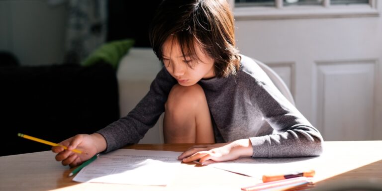 boy doing homework at kitchen table Motherly